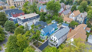 An aerial view of a residential area with houses, trees, and a clear road.