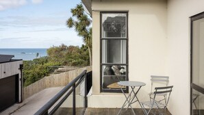 A balcony with a view of the ocean, a small table, and a chair. - St Clair Heights-Ocean views (Dunedin)