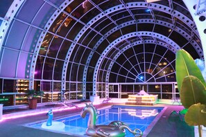 A large indoor swimming pool with a glass ceiling and a decorative swan sculpture. - Stunning 6-BR PH with Spa, Concierge, Breakfast & WiFi in Medellín (Medellín)