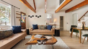 Una sala de estar moderna con sofá, mesa de centro y zona de comedor.