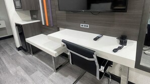 Een moderne badkamer met een grote spiegel, een wastafelmeubel met een wastafel en een toilet.