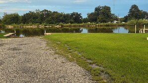 A calm lake with a grassy area and a gravel path.