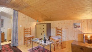 Une pièce aux murs lambrissés, contenant une table, deux chaises, un buffet et un petit bureau.