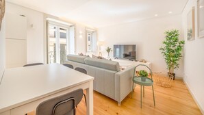Un salon moderne avec un canapé, une table à manger et un téléviseur.