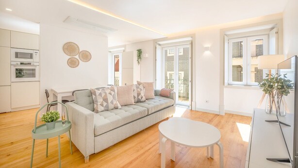 Un salon moderne avec un canapé, une table basse et un coin repas.