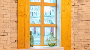 A room with a checkered floor, a white sofa, a round table, and a window with a view of a building. - Pleasure and Modernity: Dream Apartment for Rent in Saint-Roch, Quebec! (Québec)