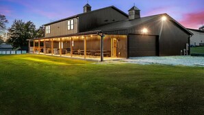 A modern building with a covered outdoor seating area, large windows, and a flat roof.