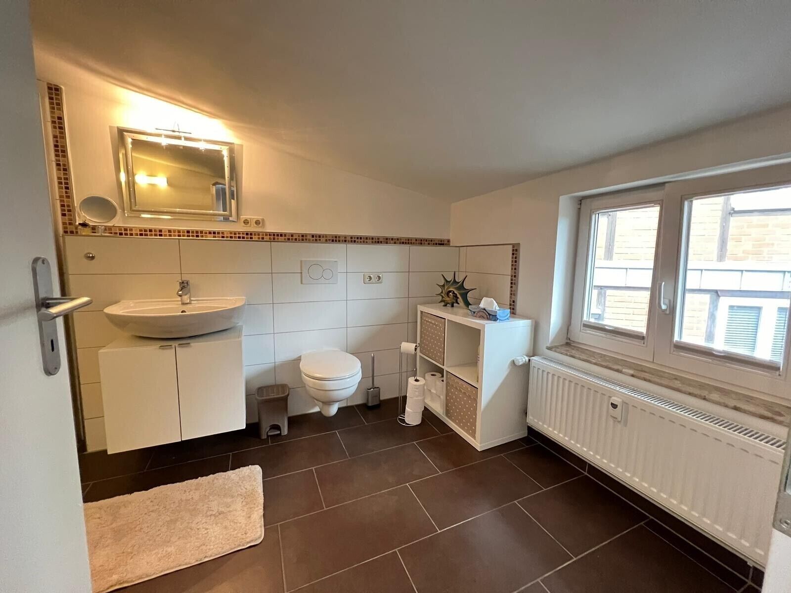 Ein Badezimmer mit Waschbecken, Toilette und Fenster.