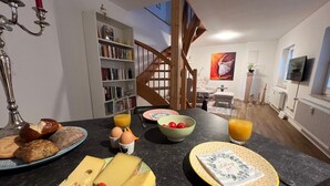 Keittiössä on aamiaispöytä, kirjahylly ja portaikko.