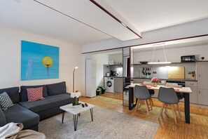 Un salon moderne avec un canapé, une table basse et un tableau accroché au mur.