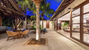 A modern outdoor living area with a pool, lounge chairs, and a dining set.