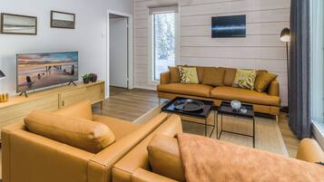 A modern living room with a sofa, coffee table, and television.