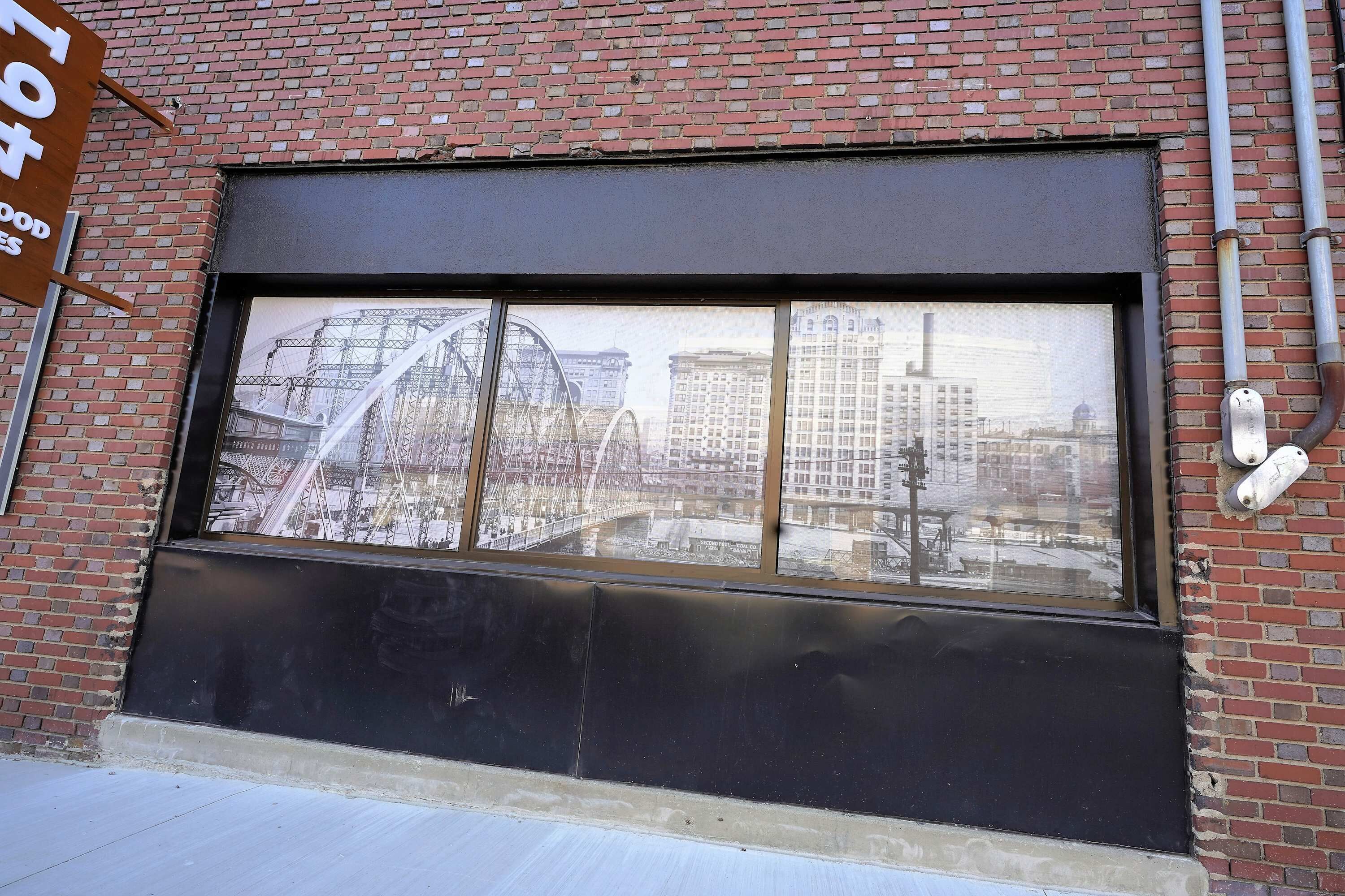 A window with a view of a cityscape, including a Ferris wheel and buildings.
