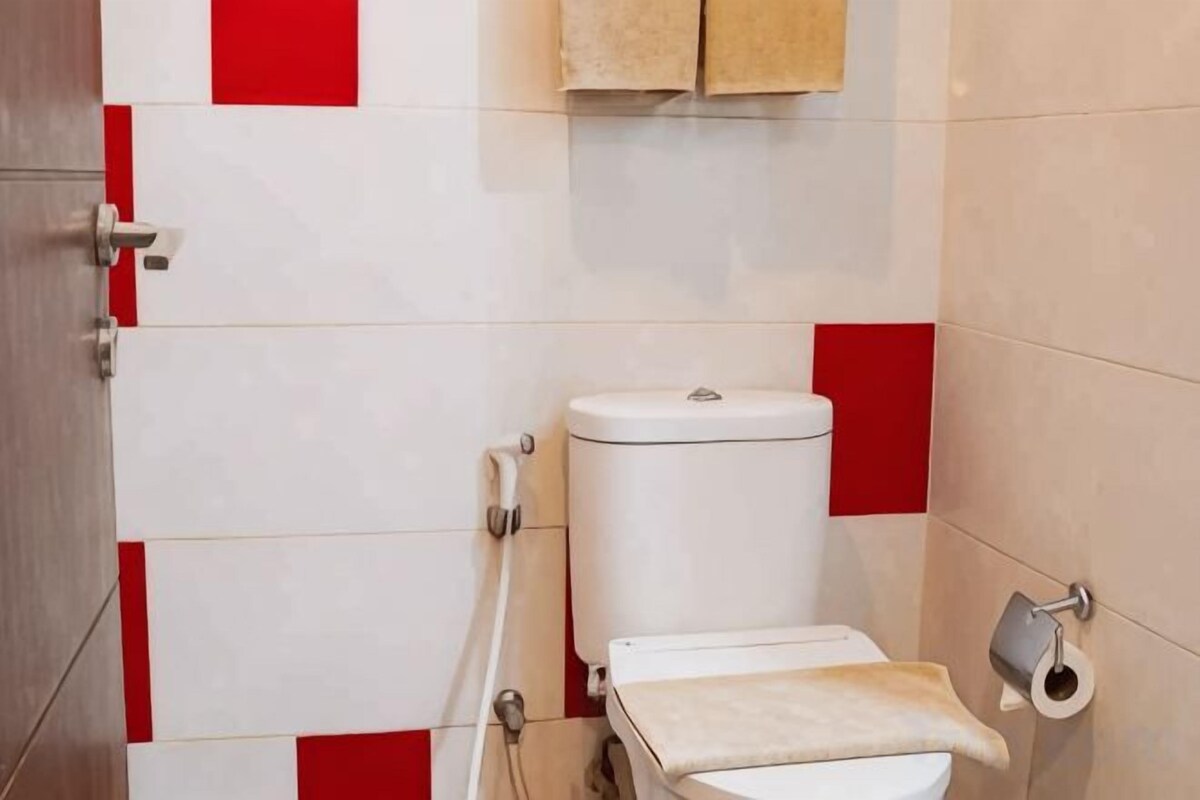 A bathroom with a toilet, a towel rack, and a toilet paper holder.