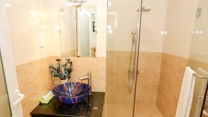 A modern bathroom with a glass-enclosed shower, a marble-tiled sink with a decorative bowl, and a white towel rack. - Co Hong Hotel DL - by BAY LUXURY (Lam Vien - Da Lat)
