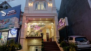 The exterior of the Co Hong Hotel with a staircase leading to the entrance, surrounded by potted plants and a parked car. - Co Hong Hotel DL - by BAY LUXURY (Lam Vien - Da Lat)