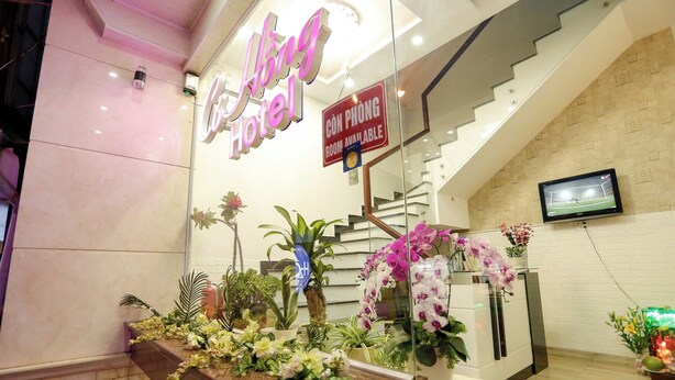 A hotel reception area with a sign indicating room availability, a staircase, and a variety of potted plants and flowers. - Co Hong Hotel DL - by BAY LUXURY (Lam Vien - Da Lat)