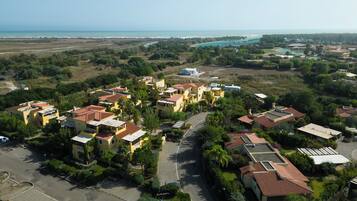 A coastal residential area with yellow buildings, a road, and a view of the sea.