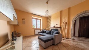 A spacious living area with a sectional sofa, a fireplace, and a large window. - #914 Home - Irpinia (Nusco)