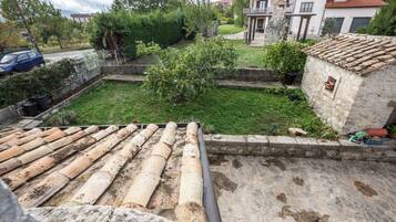 A rooftop terrace with a stone floor and a tiled roof.