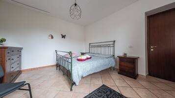 Ein Schlafzimmer mit Bett, Schminktisch, Nachttisch und einer Tür.