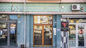 A storefront with a tiled facade, a large wooden door, and a sign for 'Beef & Wine Paletta'. - Billotti Central Loft - Cosenza (Cosenza)