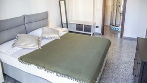 A bedroom with a bed, a bedside table, a mirror, a wardrobe, and a shower area. - Billotti Central Loft - Cosenza (Cosenza)