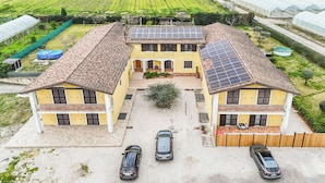 Ein zweistöckiges Haus mit einem Ziegeldach, Solaranlage und Auffahrt mit drei Autos.