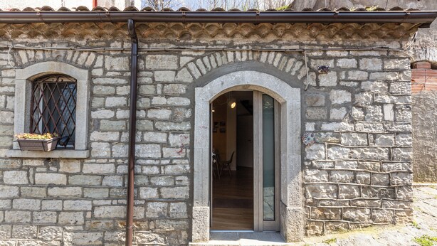 A stone building with a tiled roof, a small window with a metal grille, and a doorway leading inside. - Casa Argo Guest House (Bisaccia)