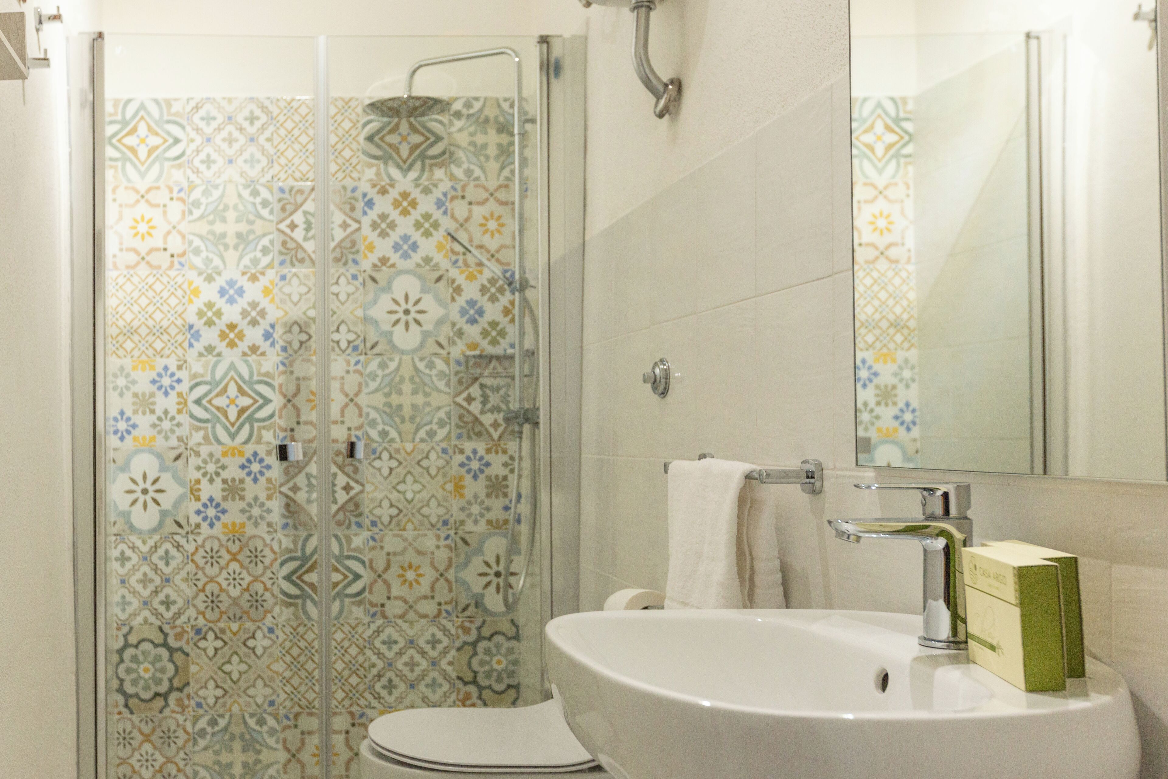 Un baño con ducha, inodoro, lavamanos y espejo.