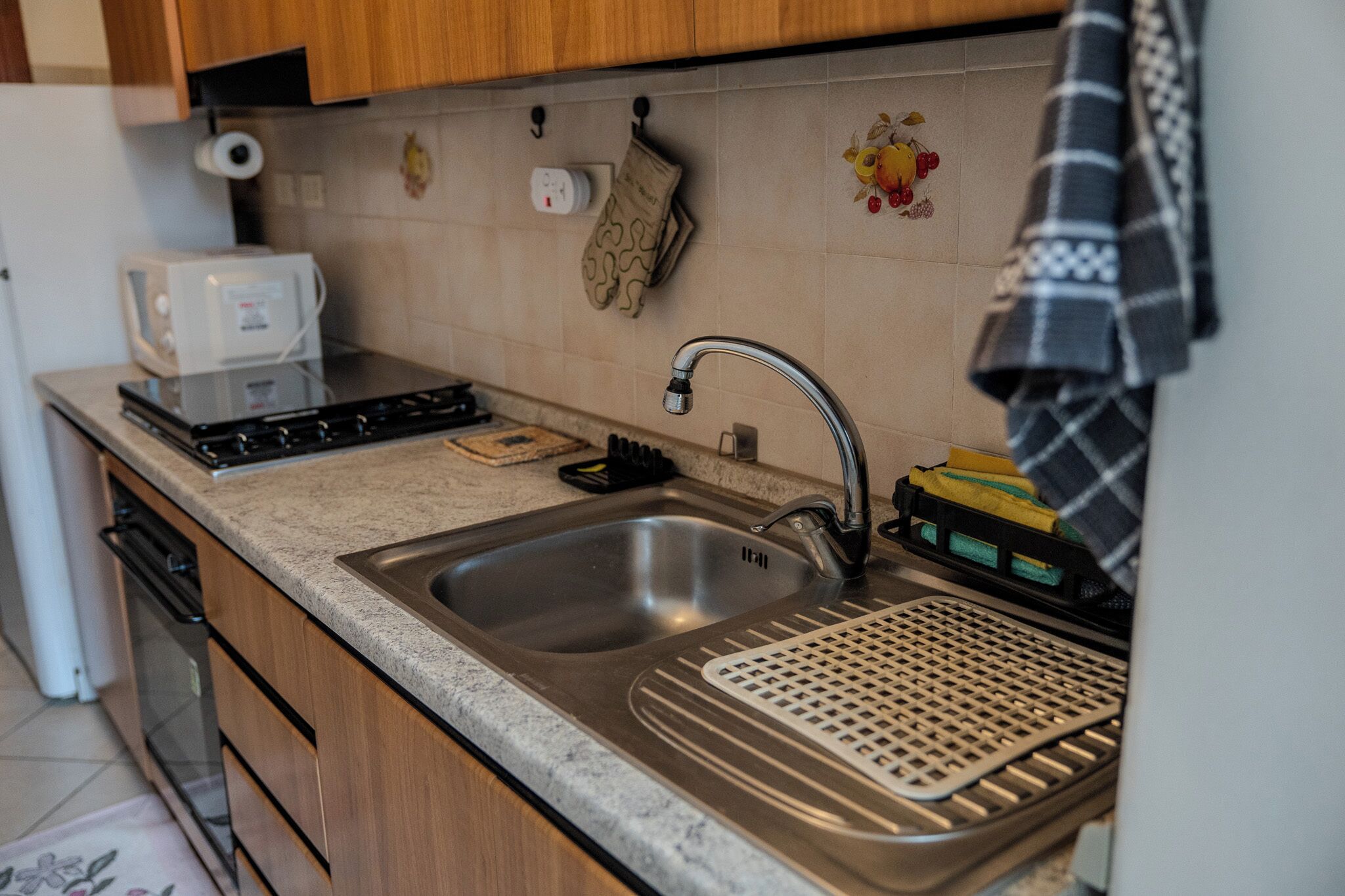 A kitchen with a stainless steel sink, a microwave, and a stove.