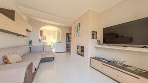 A modern living room with a sofa, TV, and decorative items. - Villa Maddalena (Scala)