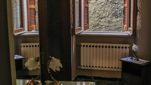 A bathroom with a glass vanity, a radiator, and a window with wooden shutters. - Brother'S Home (Civitella Casanova)