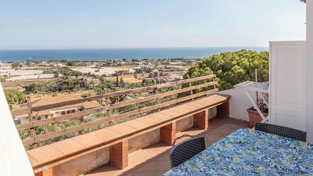 Ein Balkon mit Blick auf das Meer und die Stadt.
