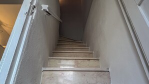 Una escalera con paredes blancas y techo de madera.