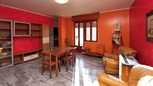A living room with a dining table, chairs, a sofa, a keyboard, and a bookshelf. - La Vecchia Cascina (Atena Lucana)