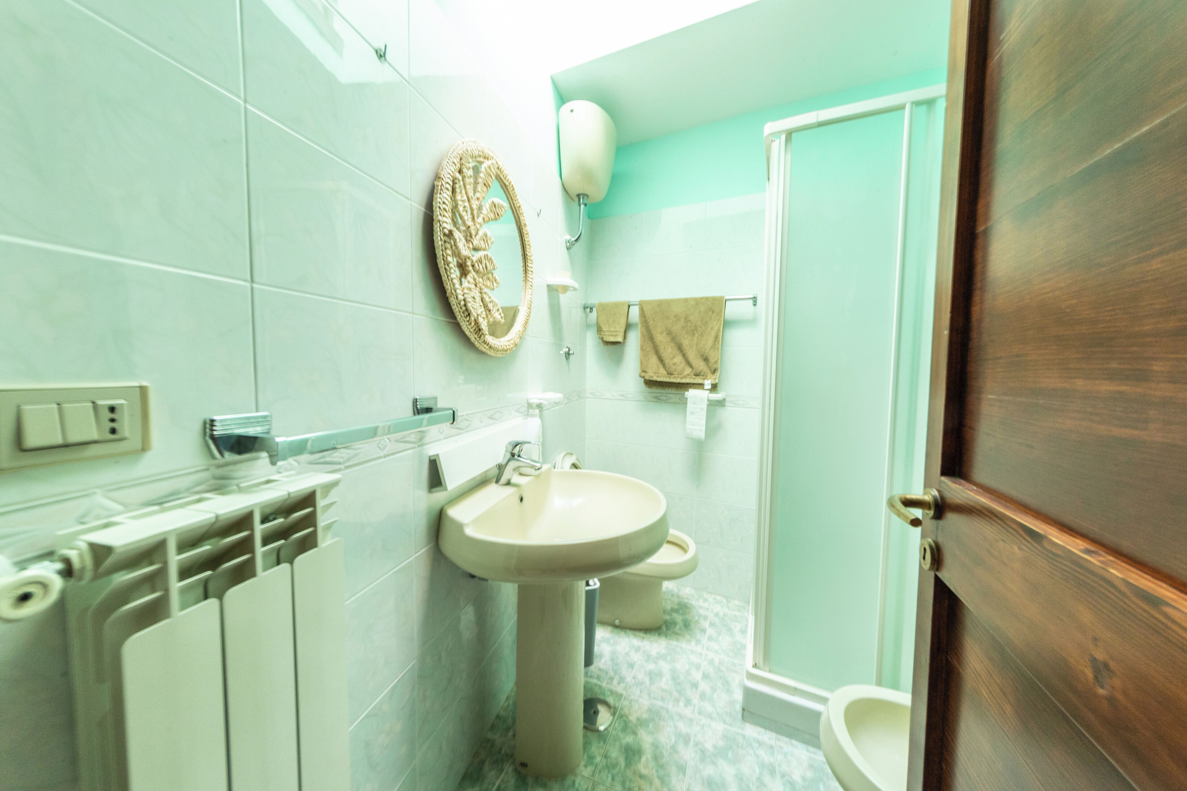 Un baño con lavamanos, inodoro y perchero para toallas.