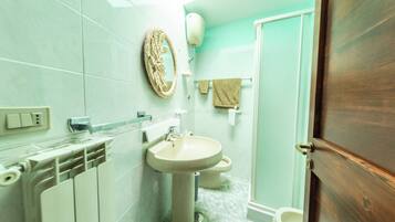 Un baño con lavamanos, inodoro y perchero para toallas.