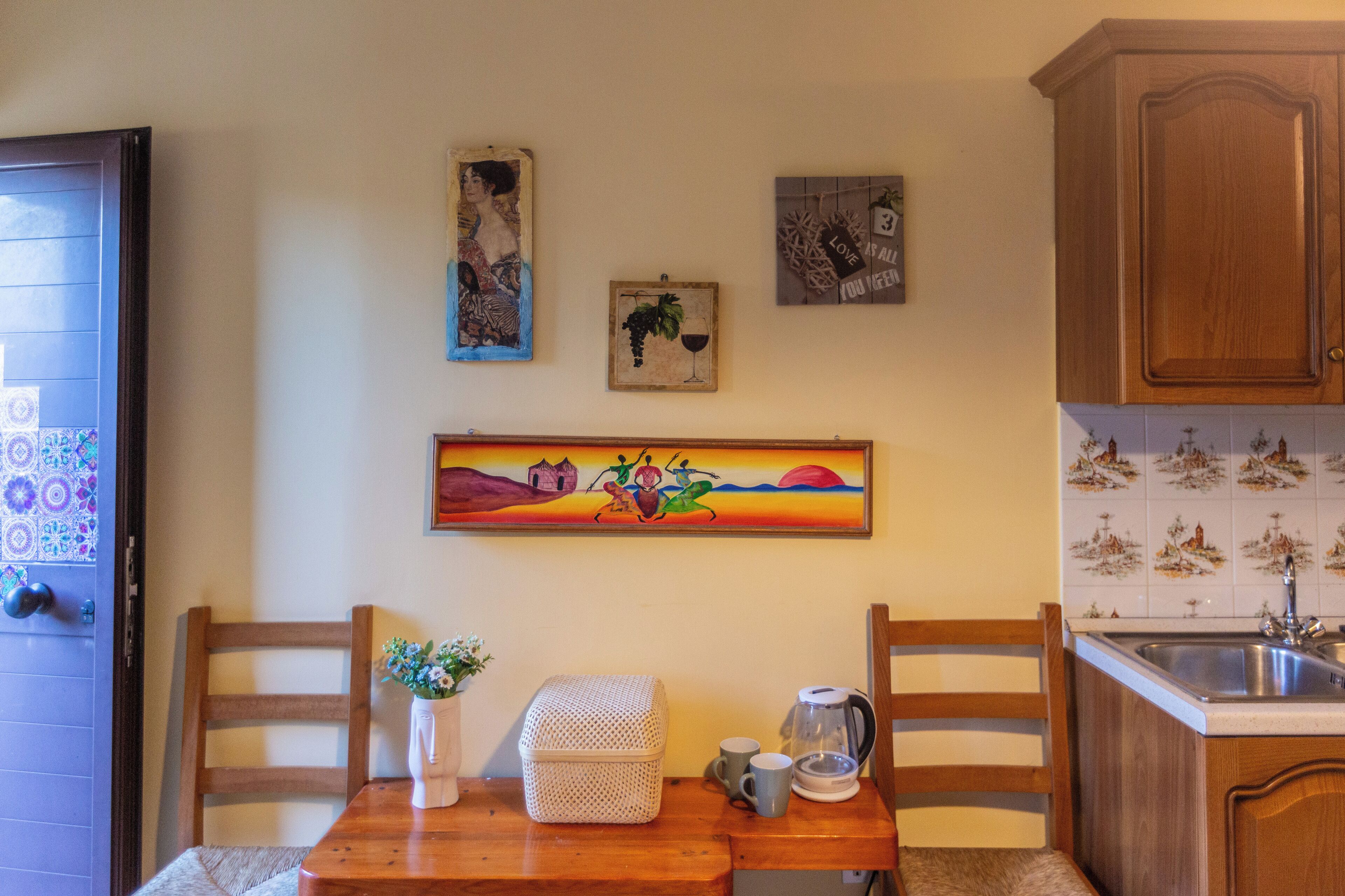 A kitchen with wooden cabinets, a tiled backsplash, and a painting on the wall.