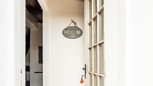 Un pasillo con techo de madera, un cartel de bienvenida y un suelo con diseño.