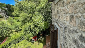 Un bâtiment en pierre avec un jardin et une chaise rouge.