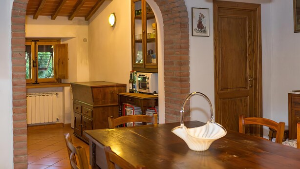 Un espace repas comprenant une table en bois, des chaises et un luminaire suspendu.