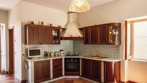 Une cuisine avec des meubles de rangement en bois, une cuisinière et un four à micro-ondes.