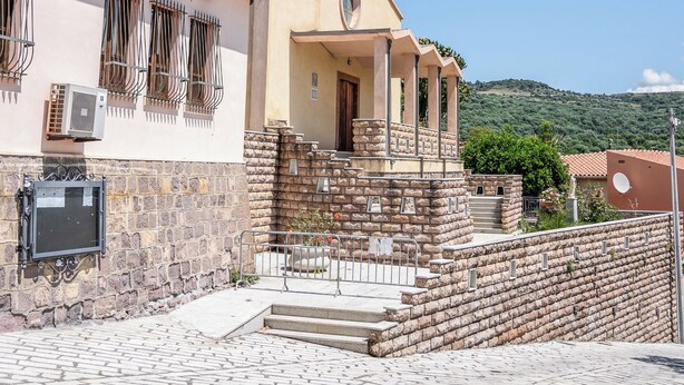 A church with a bell tower, steps leading to the entrance, and a stone wall in front. - Casa A Modolo - Francesca (Modolo)