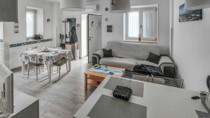 Eine moderne Wohnung mit Essbereich, Sofa und einem kleinen Tisch.