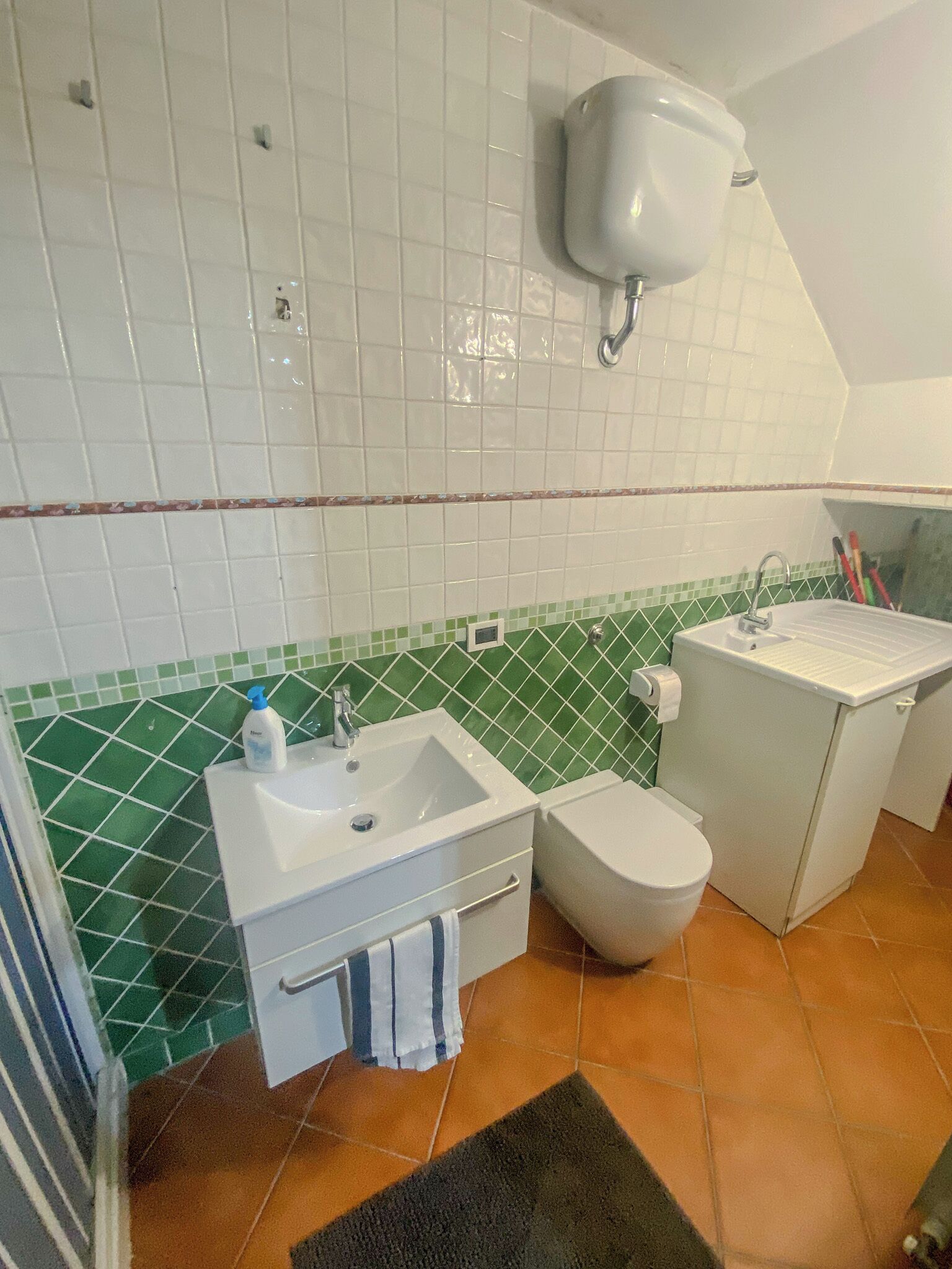 Un baño con un lavamanos blanco, un inodoro y una zona de ducha.
