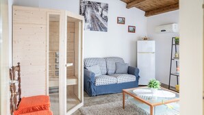 A cozy living room with a blue sofa, a wooden coffee table, and a white radiator.