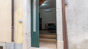 A doorway leading to a room with a wooden floor and a bed. - Sant'Janni (Buonalbergo)
