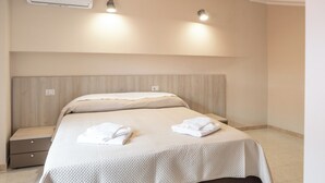 A neatly made bed with a headboard, two bedside lamps, and a small bedside table with a drawer. - Sant'Janni (Buonalbergo)