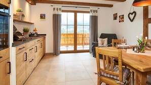 Una cucina con mobili in legno e un'area pranzo con tavolo e sedie in legno.